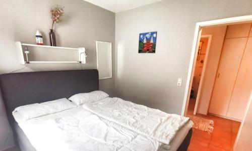 um quarto com uma cama branca num quarto em Apartmentvermittlung Mehr als Meer - Objekt 23 em Niendorf