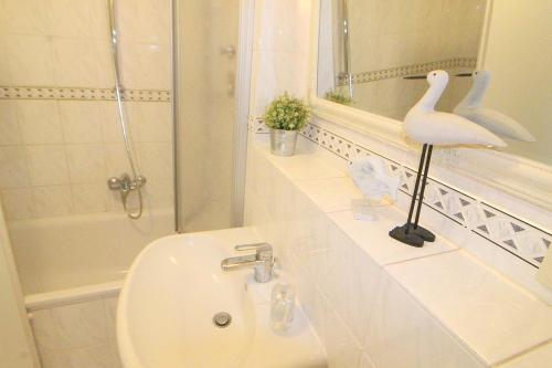 a white bathroom with a sink and a mirror at Apartmentvermittlung Mehr als Meer - Objekt 41 in Niendorf