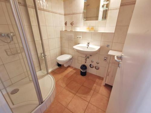uma casa de banho com um chuveiro, um lavatório e um WC. em Apartmentvermittlung Mehr als Meer - Objekt 23 em Niendorf