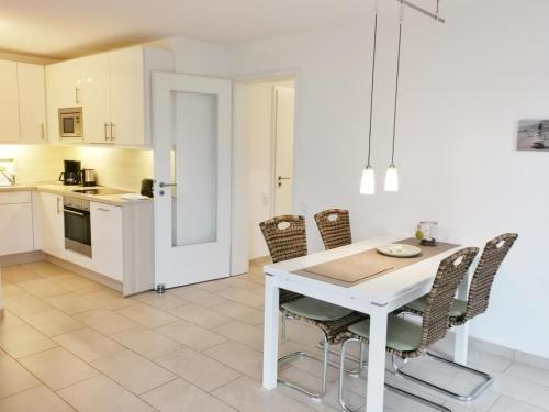 uma cozinha e sala de jantar com uma mesa branca e cadeiras em Apartmentvermittlung Mehr als Meer - Objekt 65 em Niendorf