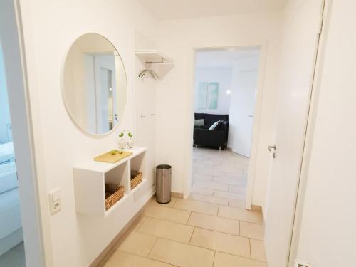 a bathroom with a sink and a mirror at Apartmentvermittlung Mehr als Meer - Objekt 65 in Niendorf