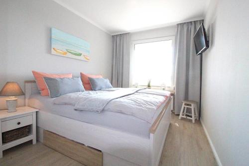- une chambre avec un grand lit et une fenêtre dans l'établissement Appartementvermittlung Mehr als Meer Objekt 36, à Niendorf