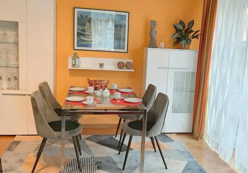 a dining room with a table and four chairs at Apartmentvermittlung Mehr als Meer - Objekt 73 in Niendorf