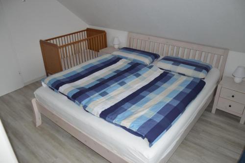 ein Bett mit zwei blauen und weißen Decken und Kissen in der Unterkunft Ferienwohnung Herzmuschel in Cuxhaven