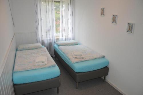 2 Einzelbetten in einem Zimmer mit Fenster in der Unterkunft Ferienwohnung Meerzeit in Cuxhaven