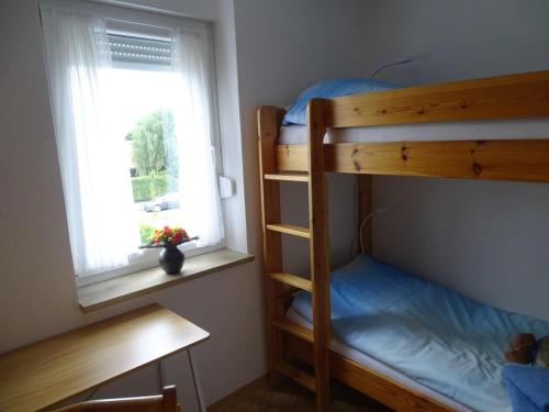 a bedroom with two bunk beds and a window at Ferienwohnung Meerleben in Duhnen