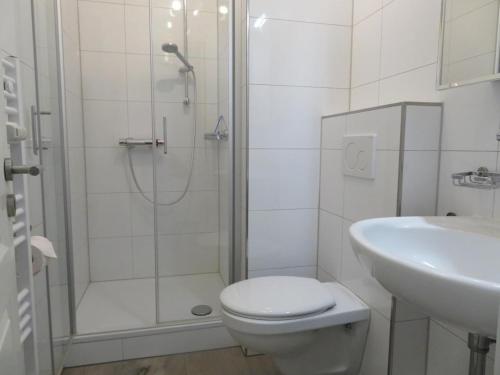 uma casa de banho com um chuveiro, um WC e um lavatório. em Ferienwohnung Meerglück em Cuxhaven