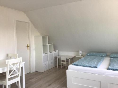 een slaapkamer met een bed en een tafel en stoelen bij Ferienwohnung Ankerplatz in Cuxhaven