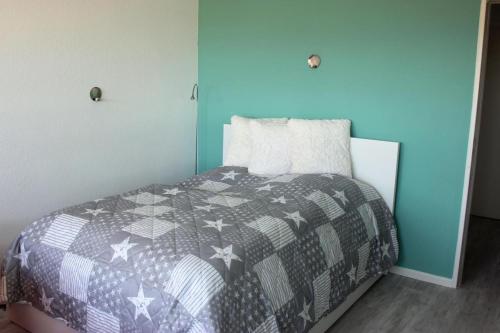 - une chambre avec un lit et une couette grise et blanche dans l'établissement Ferienwohnung am Yachthafen, à Fehmarn