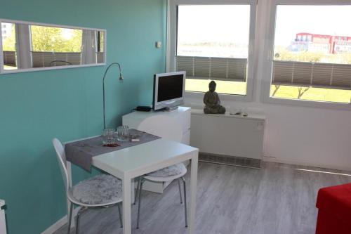 une chambre avec une table et un ordinateur sur un bureau dans l'établissement Ferienwohnung am Yachthafen, à Fehmarn