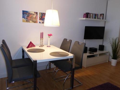 uma mesa de jantar com cadeiras e uma televisão em Ferienwohnung Meeresrauschen em Fehmarn