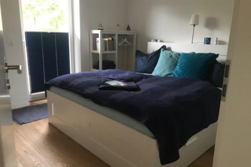 Ferienwohnung Kajüte EG في فيهمارن: غرفة نوم مع سرير ووسائد زرقاء