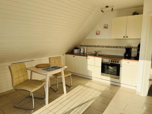 a kitchen with a table and chairs and an oven at Nixe in Scharbeutz
