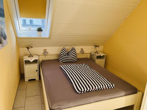 Cama pequeña en habitación pequeña con ventana en Nixe, en Scharbeutz