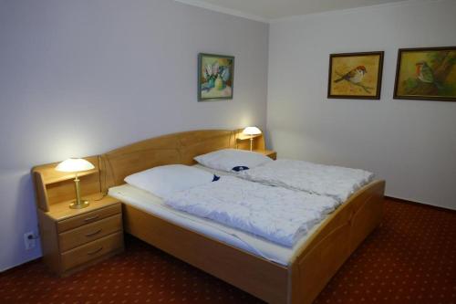 a bedroom with a bed and a nightstand and two lamps at Baltic Nr. 26 in Scharbeutz