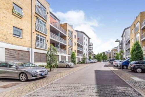 a street with cars parked on the side of a building at Town Centre Apartment in Gated Complex in Kent