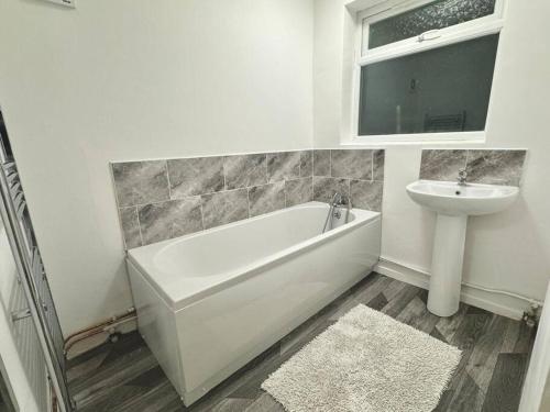 bagno bianco con lavandino, vasca e servizi igienici di Contractor Friendly - Sleeps 8 - junction 9 and 10 a Darlaston
