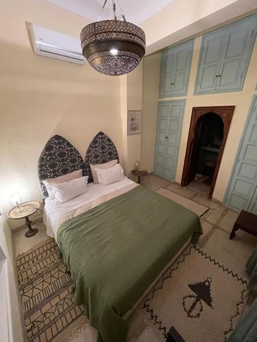 a bedroom with a bed and a chandelier at RIAD DAR NAOMI in Marrakech