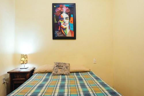 Mejor precio ubicación 2p habitación cómoda في مدينة ميكسيكو: غرفة نوم بسرير وصورة على الحائط
