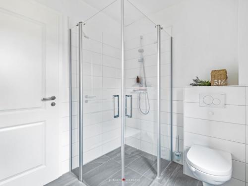 a bathroom with a glass shower with a toilet at Ferienwohnung Ostseebrise Damp in Damp