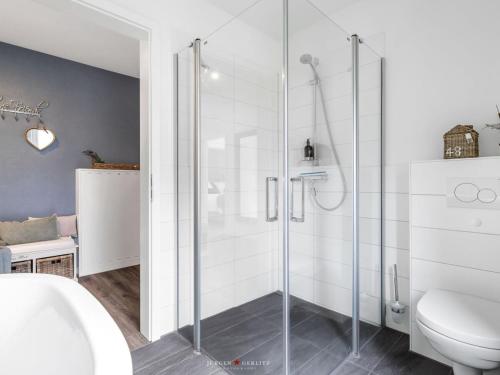 a bathroom with a glass shower with a toilet at Ferienwohnung Zum Yachthafen Damp in Damp