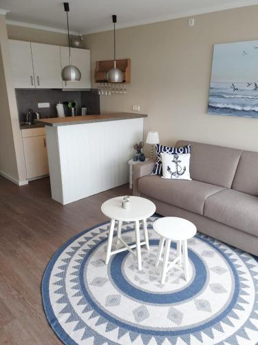 a living room with a couch and two tables at Apartment Fördeblick in Damp