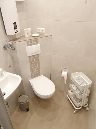 a white bathroom with a toilet and a sink at Apartment Fördeblick in Damp