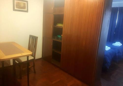 Habitación con armario, mesa, mesa y silla. en Departamento Ciudad Mendoza en Mendoza