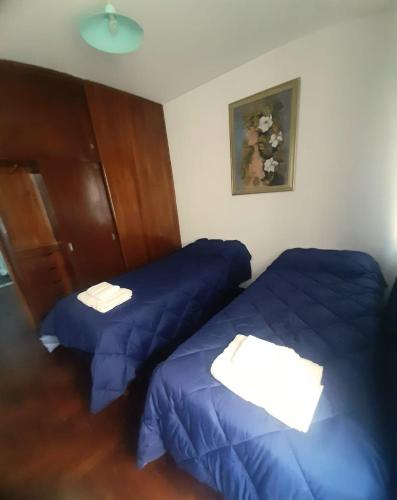 2 camas en una habitación con sábanas azules en Departamento Ciudad Mendoza en Mendoza