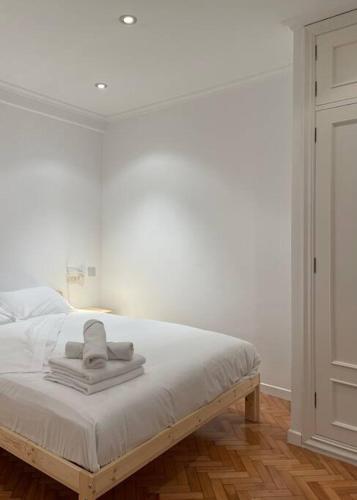 una camera da letto con un letto bianco e asciugamani di M. Valladares4 by VigoVacaciones a Vigo