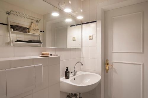 a white bathroom with a sink and a mirror at Kutscherhaus - Kutscher Karl in Manhagen