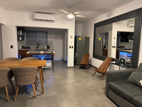 カボ・サン・ルーカスにあるDepartamento en 1er piso 2 bdr 2bath tezalのリビングルーム(テーブル、椅子付)、キッチン