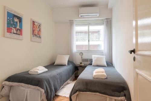 2 camas en una habitación pequeña con ventana en Fliphaus Charcas 3000 - 4 Bd Alto Palermo en Buenos Aires