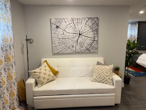 una sala de estar con un sofá blanco con almohadas en Suite au centre de l’Estrie, en Ange-Gardien