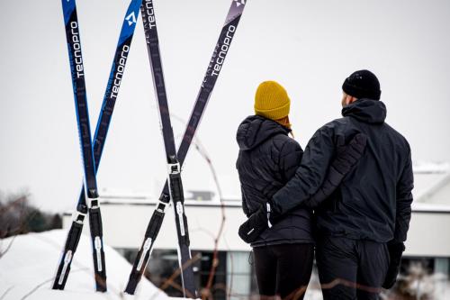 two people standing in front of skis in the snow at Estérel Resort in Esterel