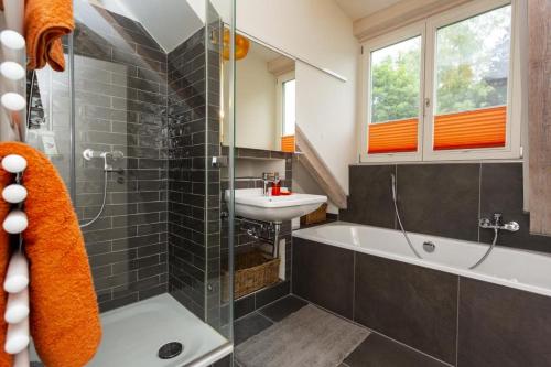 a bathroom with a sink and a bath tub and a sink at Ferienwohnung DAS SCHELLENWIES in Murnau in Murnau am Staffelsee