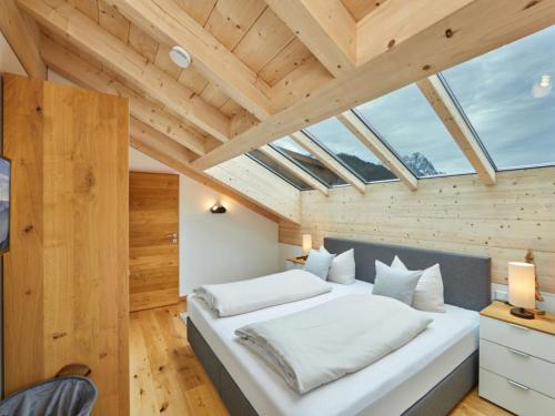 ein Schlafzimmer mit einem großen weißen Bett in einem Zimmer mit Holzdecken in der Unterkunft Fewo Sterntaler DG mit Bergblick in Garmisch-Partenkirchen