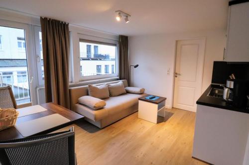 uma sala de estar com um sofá e uma mesa em Apartmenthuus König em Norderney