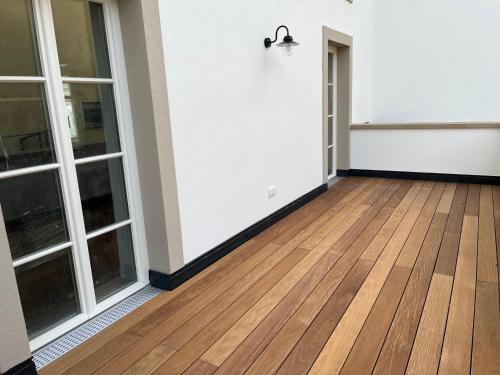 an empty room with a wooden floor and windows at Gästehaus Cantzheim in Kanzem