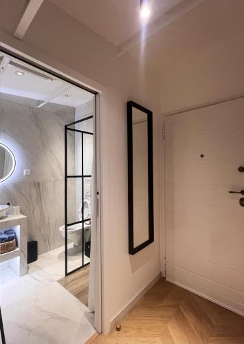 - une salle de bains avec un miroir à côté d'une porte dans l'établissement Studio cosy à Cannes 18 m² avec jardin privé 1 steampod, à Cannes