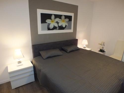 ein Schlafzimmer mit einem Bett mit zwei Nachttischen und zwei Lampen in der Unterkunft Watten-Blick 2 in Cuxhaven