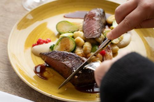 a plate of food with meat and vegetables on a table at Estérel Resort in Esterel