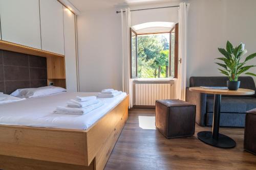 - une chambre avec un lit, une table et une fenêtre dans l'établissement Villa Orta, à Orta San Giulio