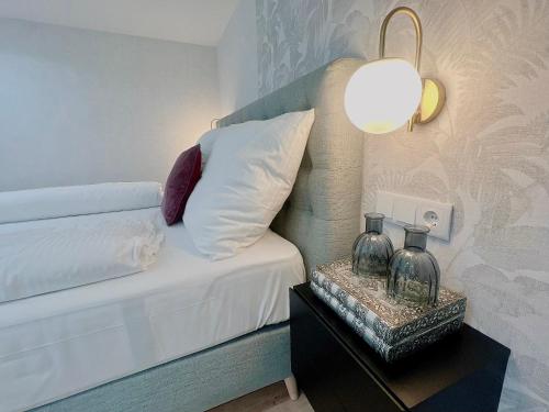 une chambre avec un lit et une table de chevet avec une lampe dans l'établissement Zeus Design Loft Apartments Braunhirschen, à Vienne