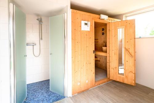 a bathroom with a shower and a wooden door at Haus Bendix in Dagebüll