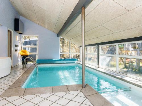 a large swimming pool in a room with windows at 12 person holiday home in Glesborg in Glesborg