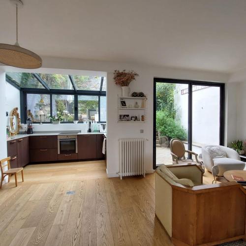 une cuisine et un salon avec un canapé et une table dans l'établissement Spacious family house close to Paris, à Puteaux