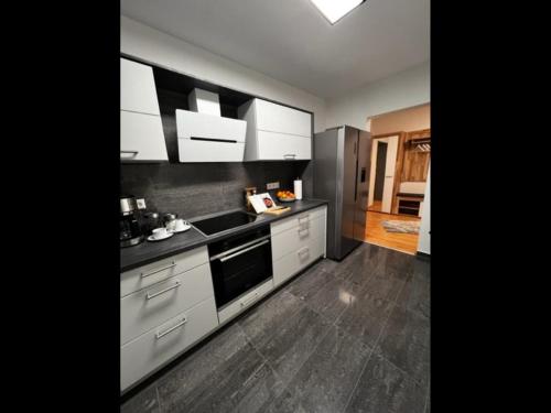 una cocina con armarios blancos y encimeras negras en NEU! Ferienwohnung Feuergasse, 