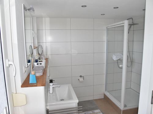 a white bathroom with a shower and a sink at NEU! Ferienhaus Schaaf in Hillscheid