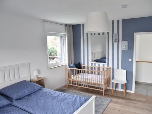a bedroom with a bed and a baby crib at NEU! Ferienhaus Schaaf in Hillscheid